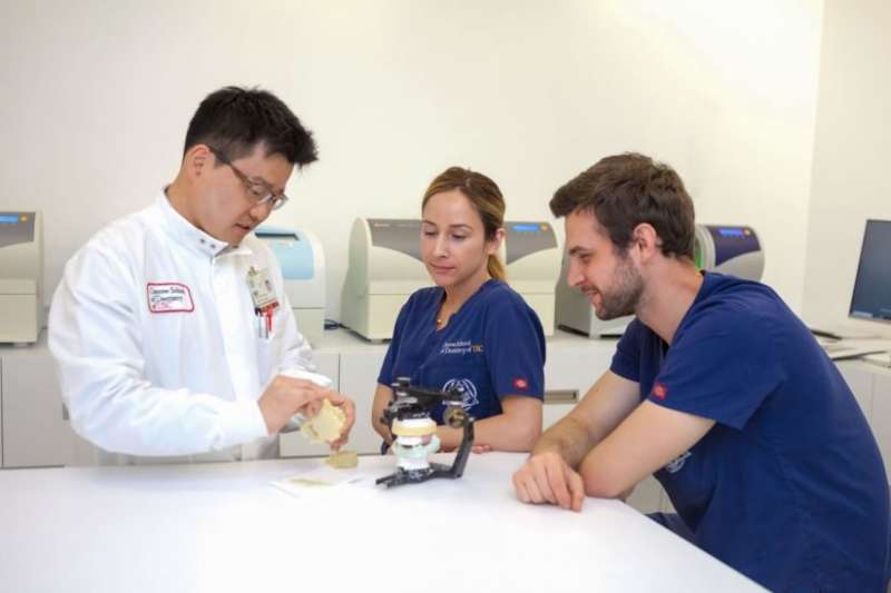 Tae Kim explains 3-D printing process to dental students Nikki Restrepo and Robert Zama. Credit: Tan Khuu