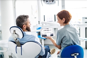 Dentist showing x-ray to a dental patient