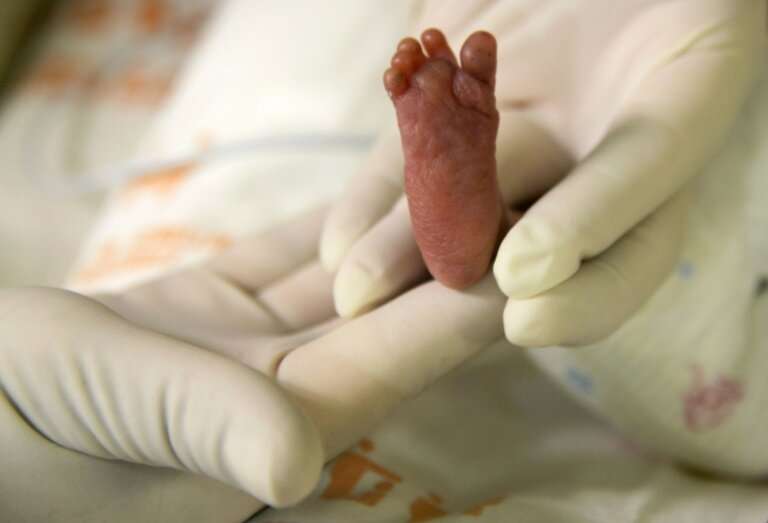 A pediatric nurse holds a premature baby after feeding him at Medellín's General hospital on August 20, 2014 in Medellin, Colomb